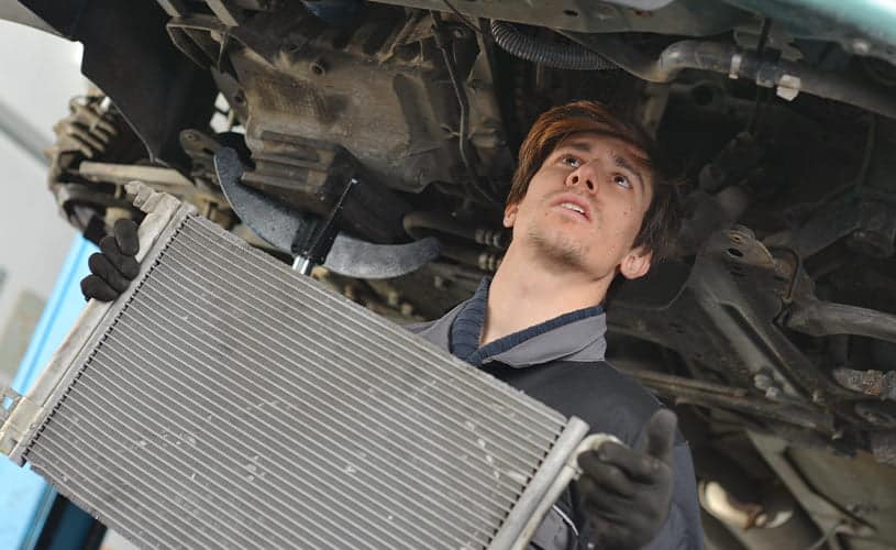 mechanic servicing car radiator
