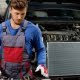 Mechanic inspecting car radiator for EV battery thermal management and cooling system service.