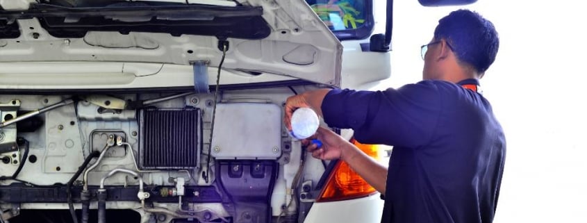 truck driver refilling water in truck radiator