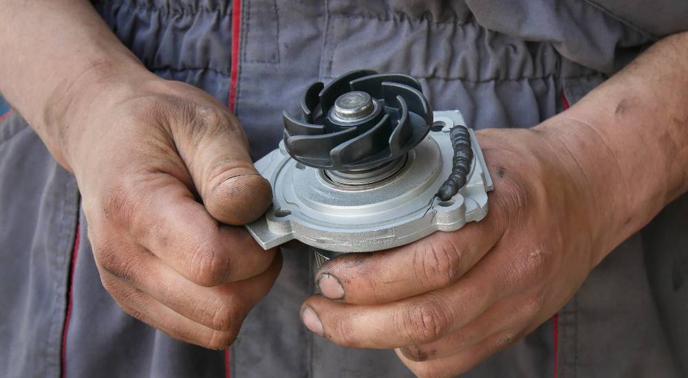 mechanic handling a water pump
