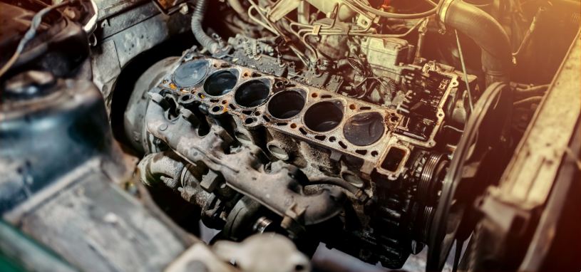 A damaged, rusty-looking car engine head gasket.
