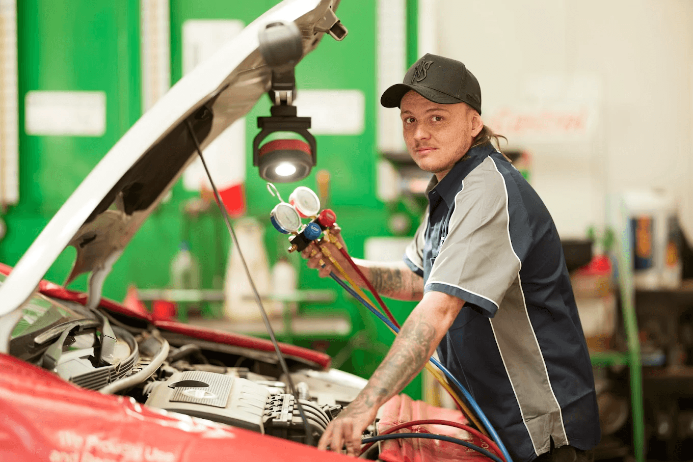 Brisbane mechanic repairing a car radiator and inspecting coolant hoses.